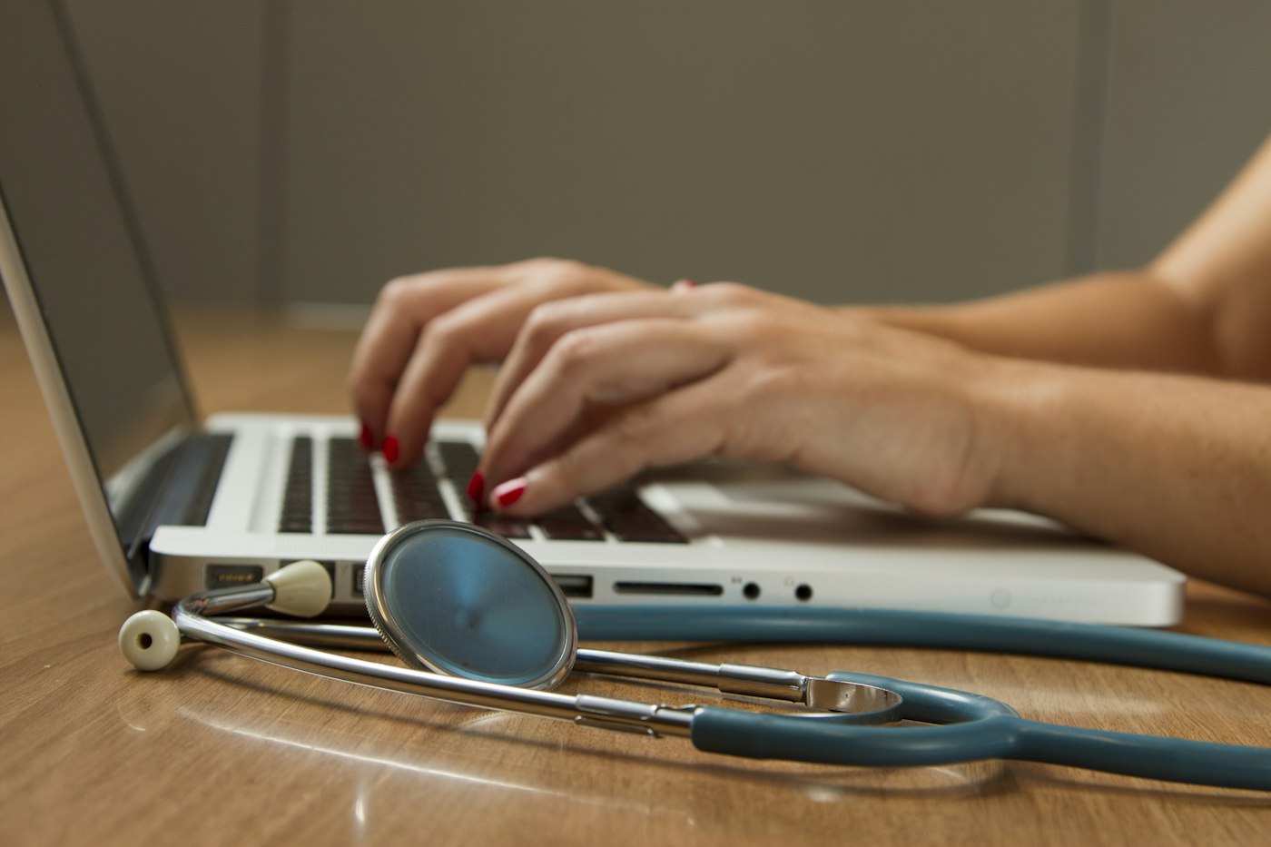 Clinician speaking with a colleague beside a laptop